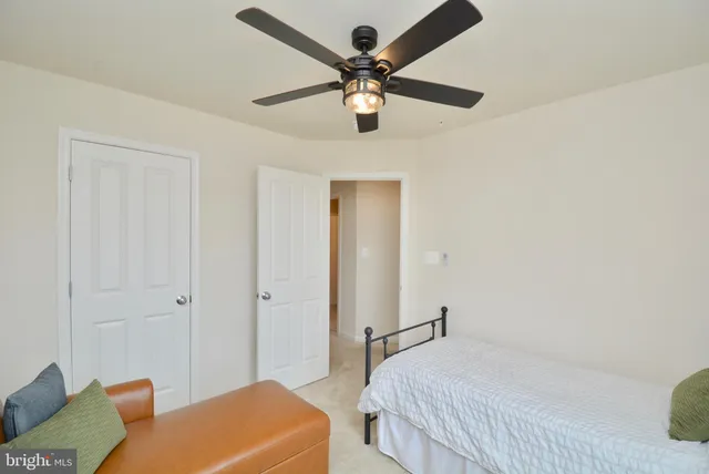a bedroom with a bed and a ceiling fan