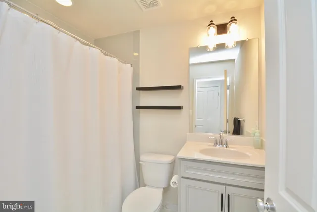 a bathroom with a sink toilet and mirror