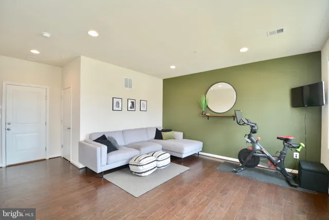 a living room with furniture a mirror and a flat screen tv