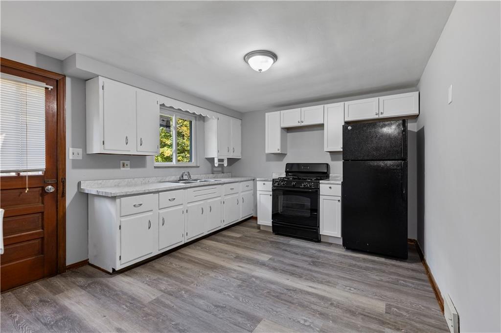 124 Saunders Station Road Trafford, PA 15085 - Photo 3 of 27 a kitchen with granite countertop a refrigerator and a stove top oven