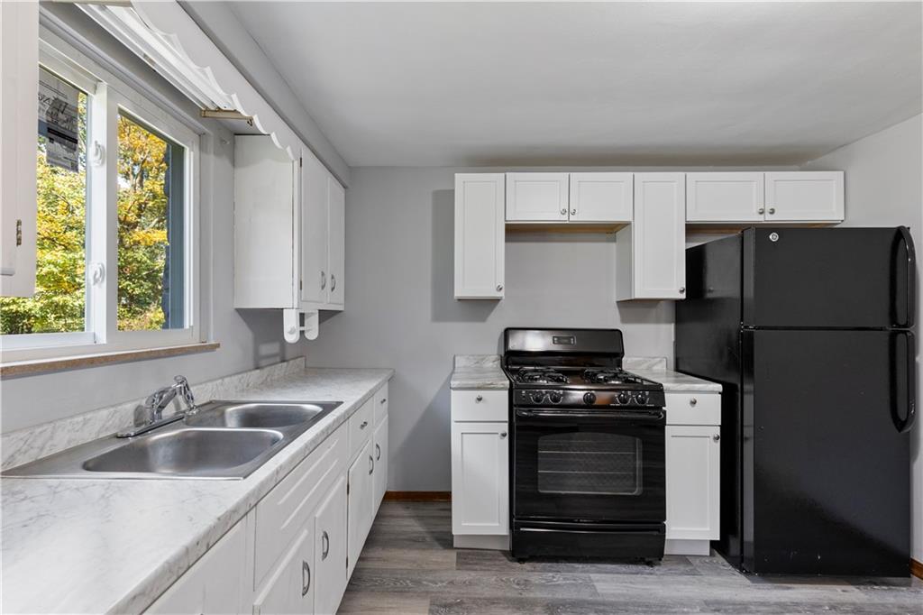 124 Saunders Station Road Trafford, PA 15085 - Photo 4 of 27 a kitchen with a sink stove and refrigerator