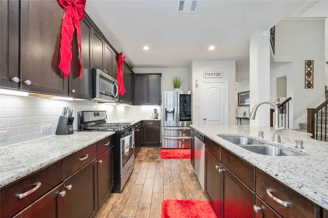 a kitchen with stainless steel appliances granite countertop a sink stove and cabinets