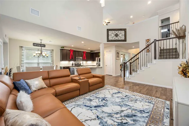 a living room with furniture kitchen view and a wooden floor