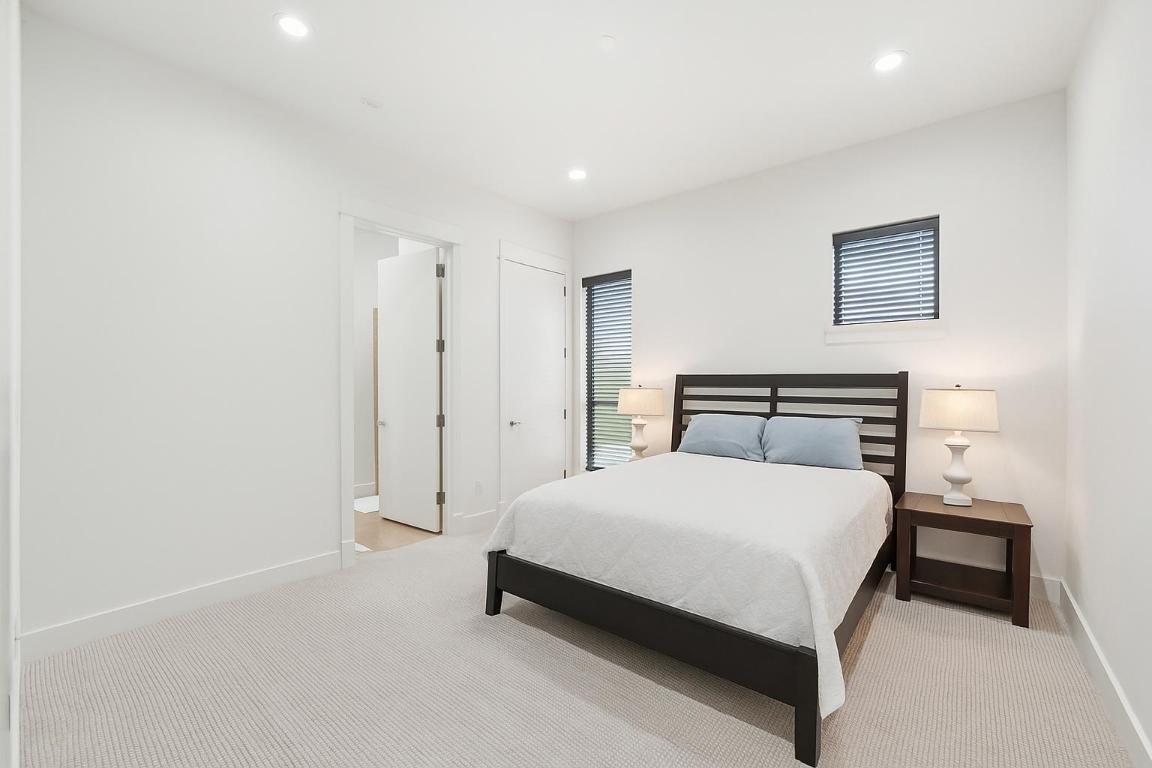 1101 Ivean Pearson Road, Unit E203 Lago Vista, TX 78645 - Photo 23 of 29 a spacious bedroom with a bed and a lamp