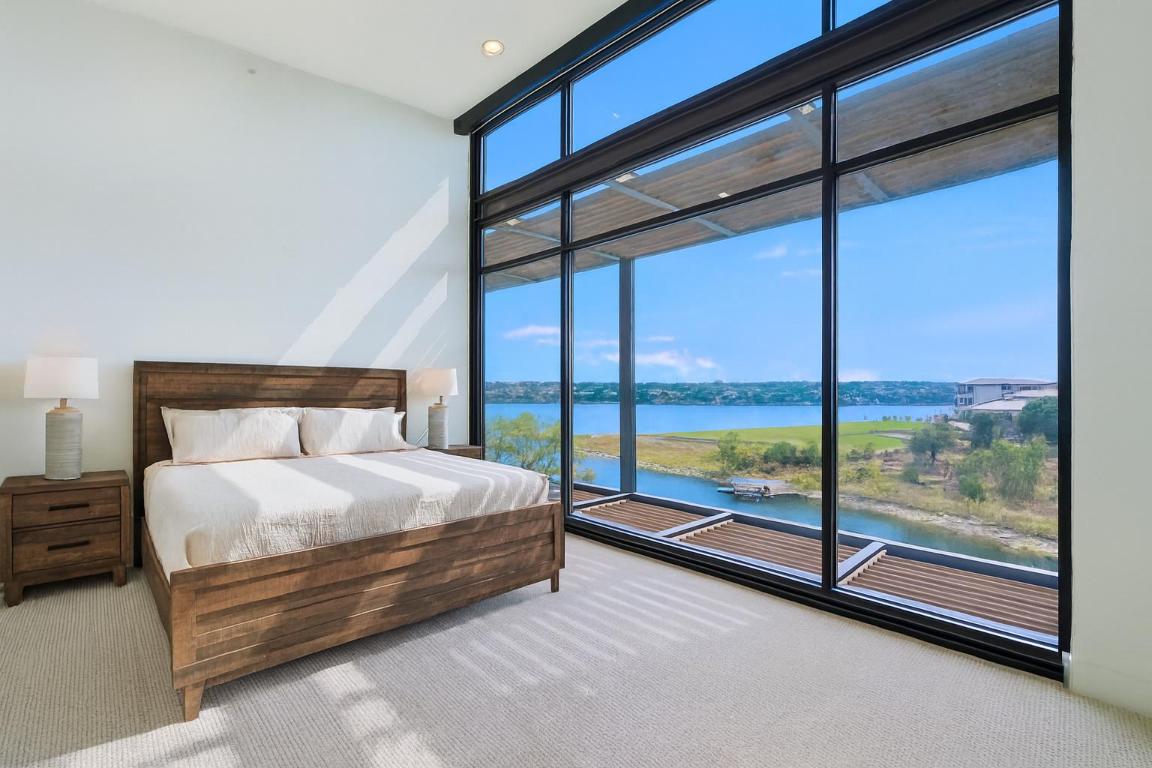 1101 Ivean Pearson Road, Unit E203 Lago Vista, TX 78645 - Photo 10 of 29 a large bed sitting in a bedroom next to a large window