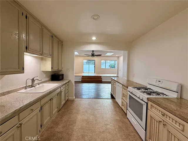 a large kitchen with stainless steel appliances granite countertop a stove a sink and a refrigerator