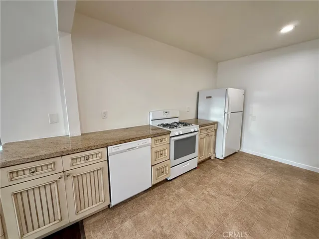 a kitchen with stainless steel appliances white cabinets and a window