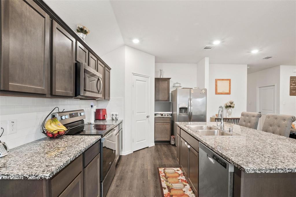 151 Seabiscuit Road Caddo Mills, TX 75135 - Photo 11 of 40 a kitchen with stainless steel appliances granite countertop a sink stove and refrigerator