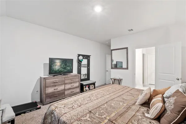 a bedroom with bed and tv with wooden floor