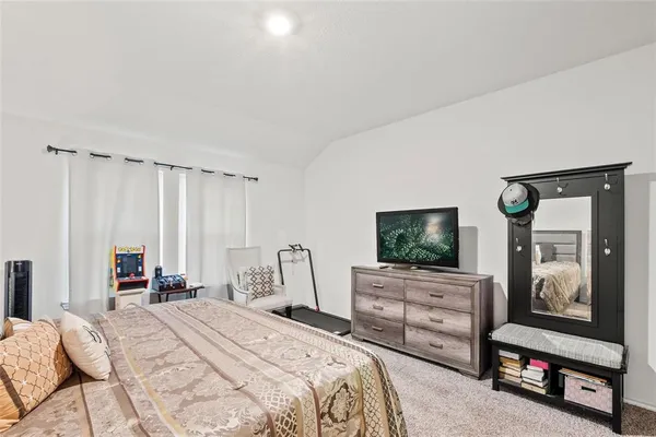 a bedroom with a bed a television and dresser