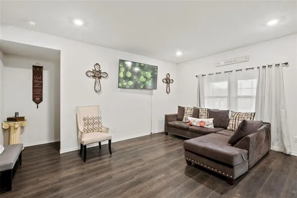 a living room with furniture and a wooden floor