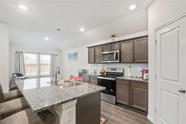 a kitchen with stainless steel appliances granite countertop a sink stove and cabinets