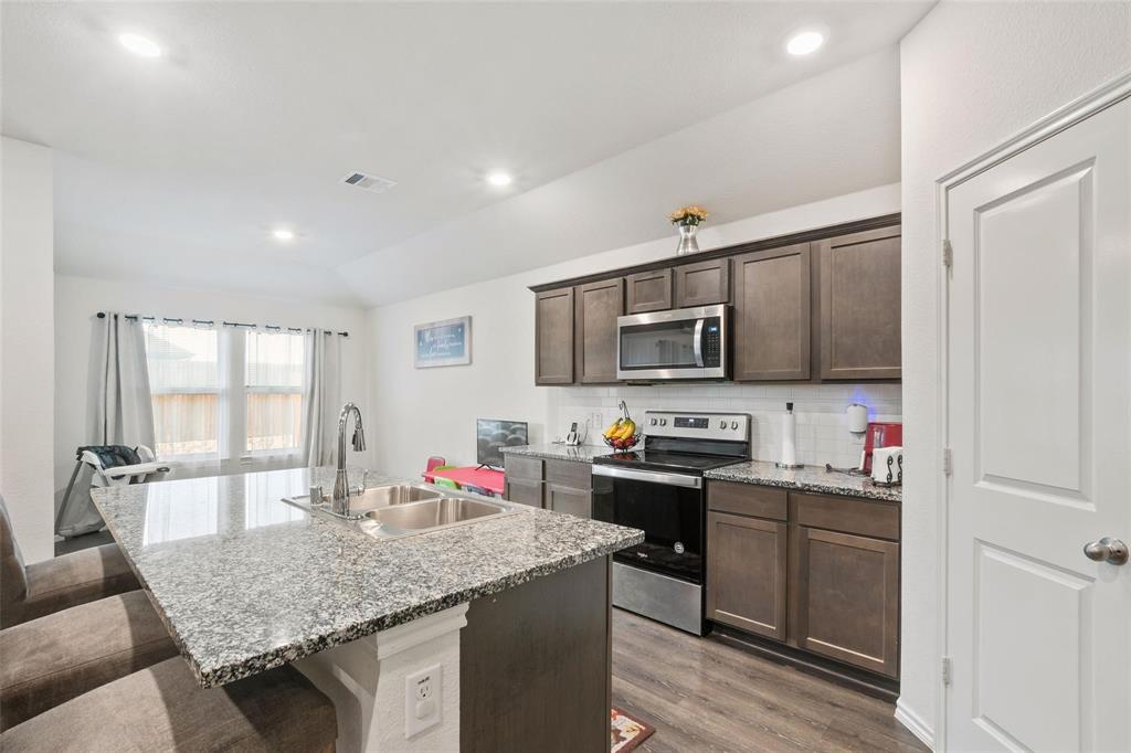 151 Seabiscuit Road Caddo Mills, TX 75135 - Photo 8 of 40 a kitchen with stainless steel appliances granite countertop a sink stove and cabinets