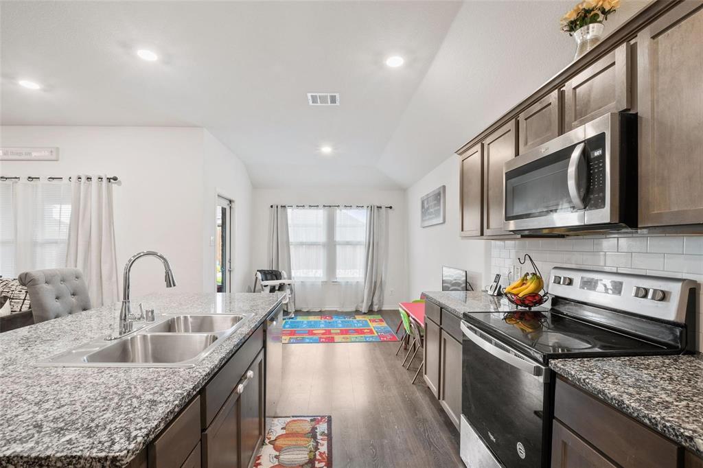 151 Seabiscuit Road Caddo Mills, TX 75135 - Photo 9 of 40 a kitchen with stainless steel appliances granite countertop a sink stove and refrigerator