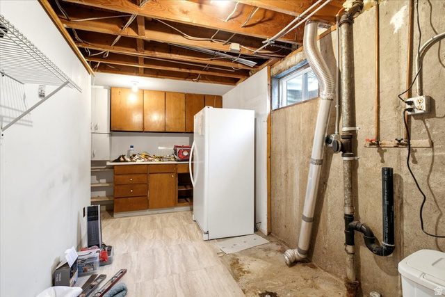 272 East 1400th Street North Bountiful, UT 84010 - Photo 27 of 38 Unfinished basement space for laundry and storage with a small window and a white freezer