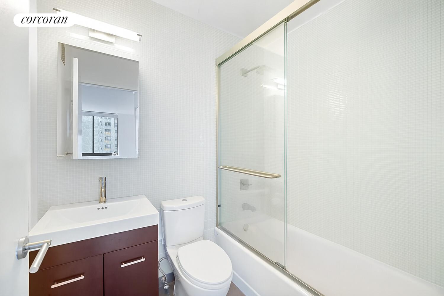 250 East 40th Street, Unit 17F Manhattan, NY 10016 - Photo 5 of 16 a bathroom with a sink a toilet and shower