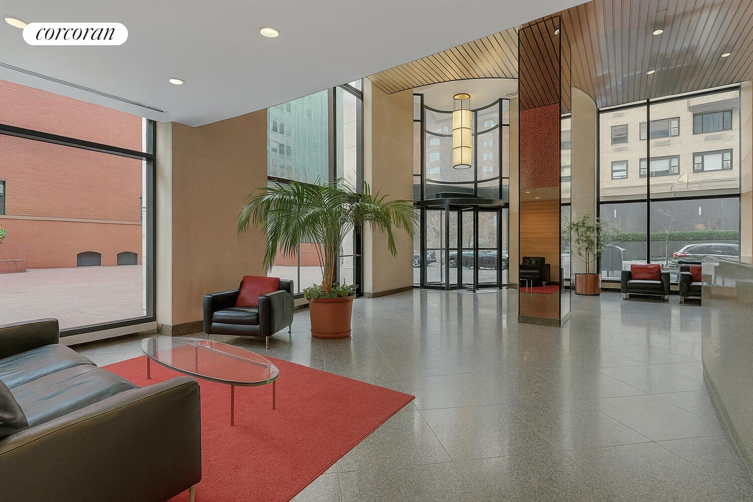 250 East 40th Street, Unit 17F Manhattan, NY 10016 - Photo 9 of 16 a living room with furniture a flat screen tv and floor to ceiling window