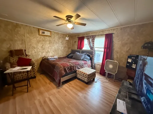 a bedroom with a bed and wooden floor