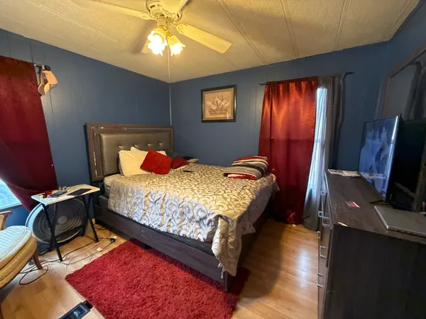a bedroom with double bed and a flat tv screen on dresser