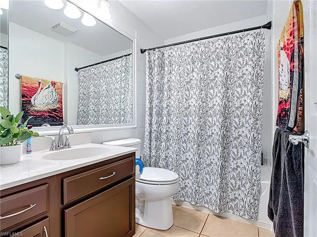 a bathroom with a granite countertop sink a toilet and a shower