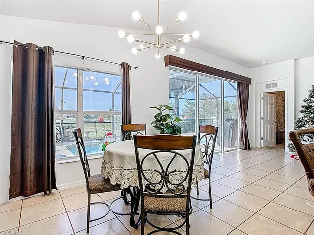 a dining room with furniture and a floor to ceiling window