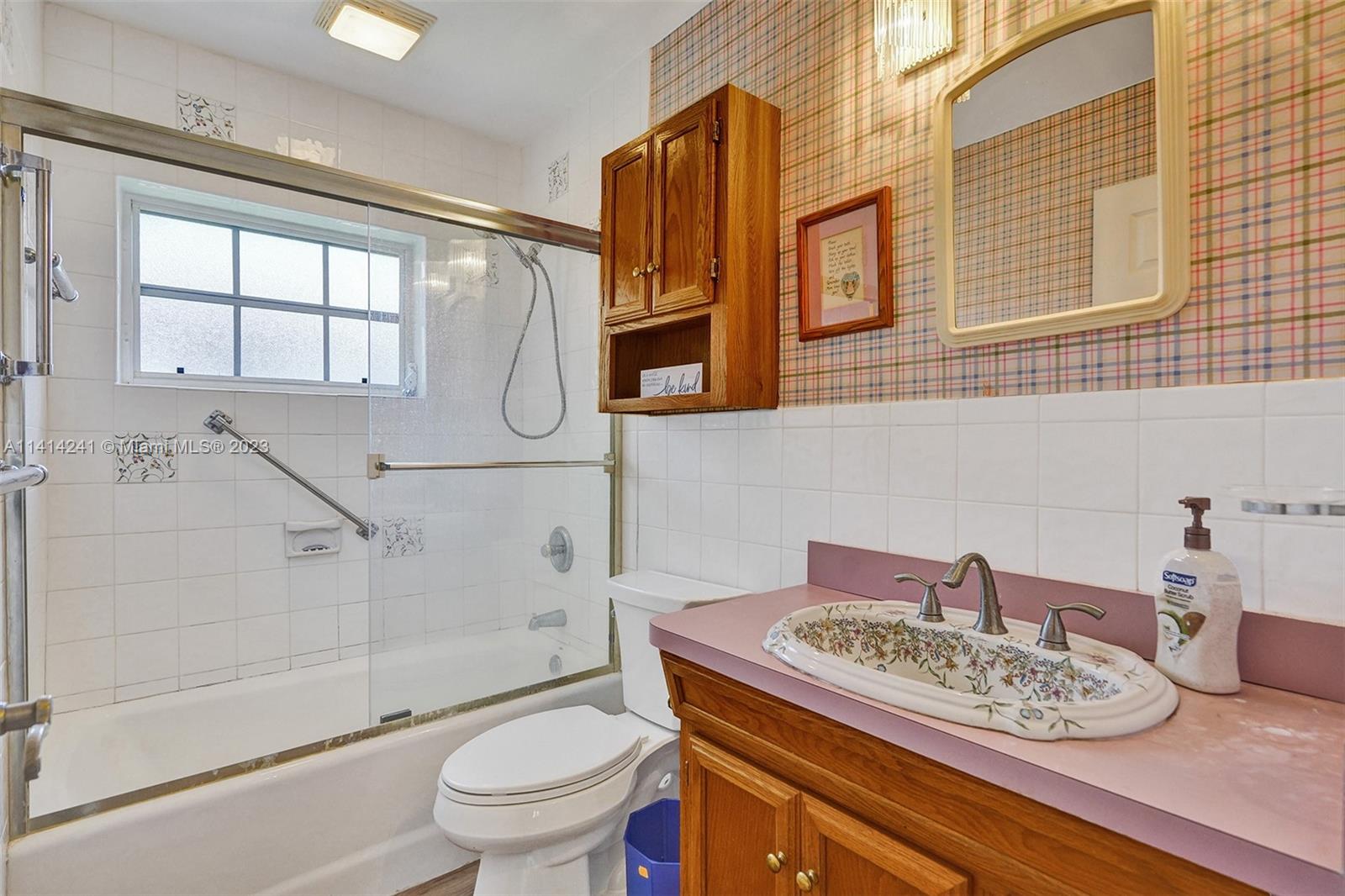 9020 Southwest 187th Terrace Cutler Bay, FL 33157 - Photo 31 of 55 a bathroom with a granite countertop sink a toilet and a shower