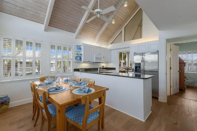 a kitchen with a dining table chairs and refrigerator