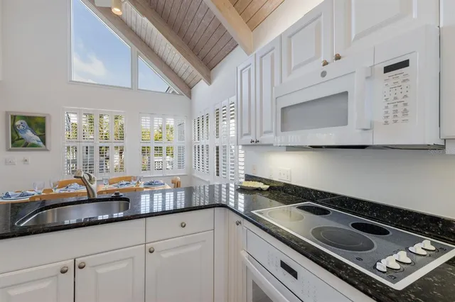 a kitchen with granite countertop a sink stove and cabinets