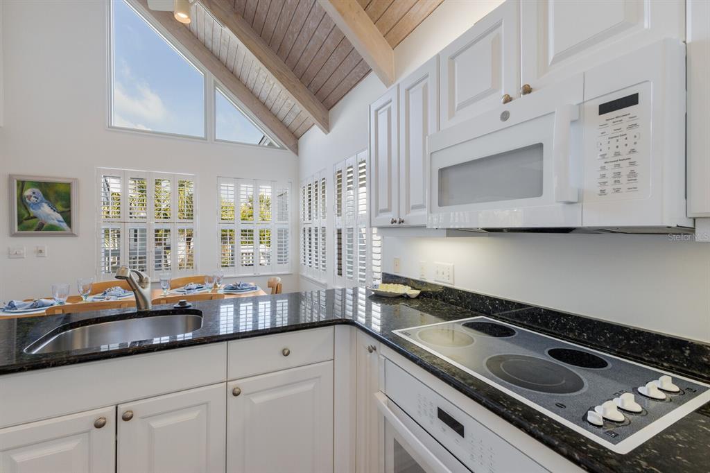 5000 Gasparilla Road, Unit VH37 Boca Grande, FL 33921 - Photo 14 of 54 a kitchen with granite countertop a sink stove and cabinets
