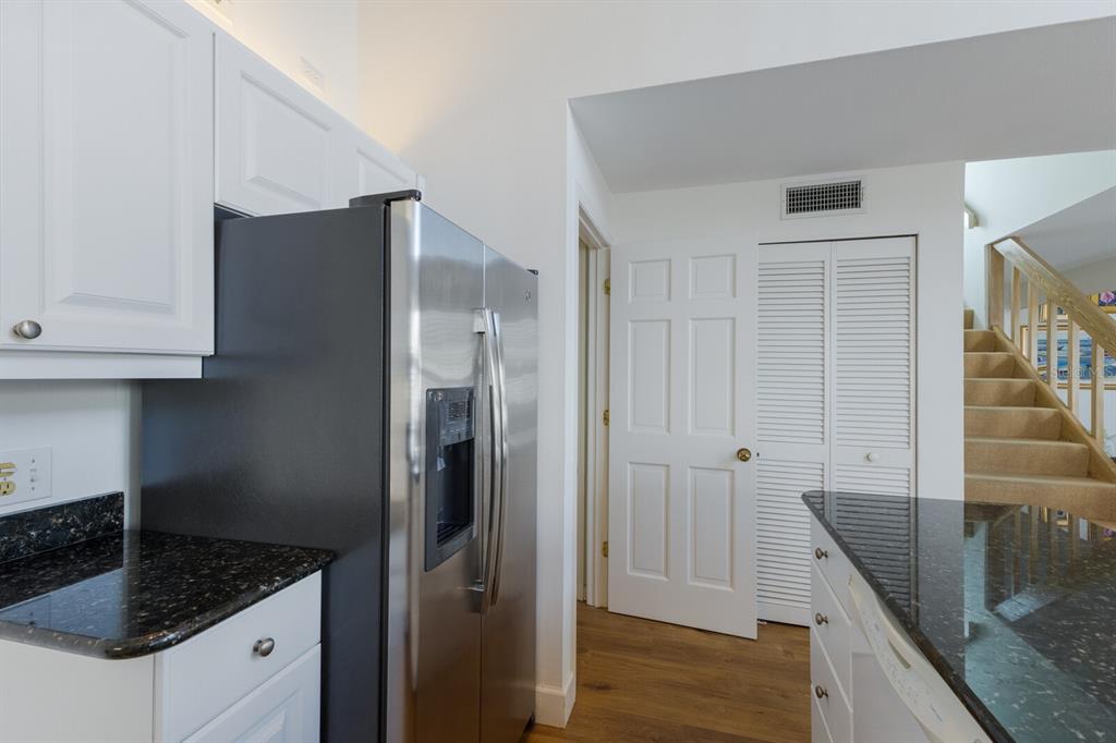 5000 Gasparilla Road, Unit VH37 Boca Grande, FL 33921 - Photo 15 of 54 a kitchen with granite countertop a refrigerator a sink and white cabinets