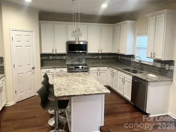 a kitchen with kitchen island granite countertop wooden cabinets and a sink