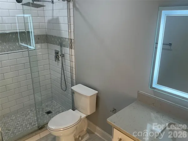 a white toilet sitting next to a shower