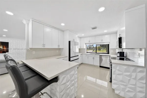 a kitchen with white cabinets and appliances