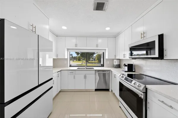 a kitchen with white cabinets and white appliances