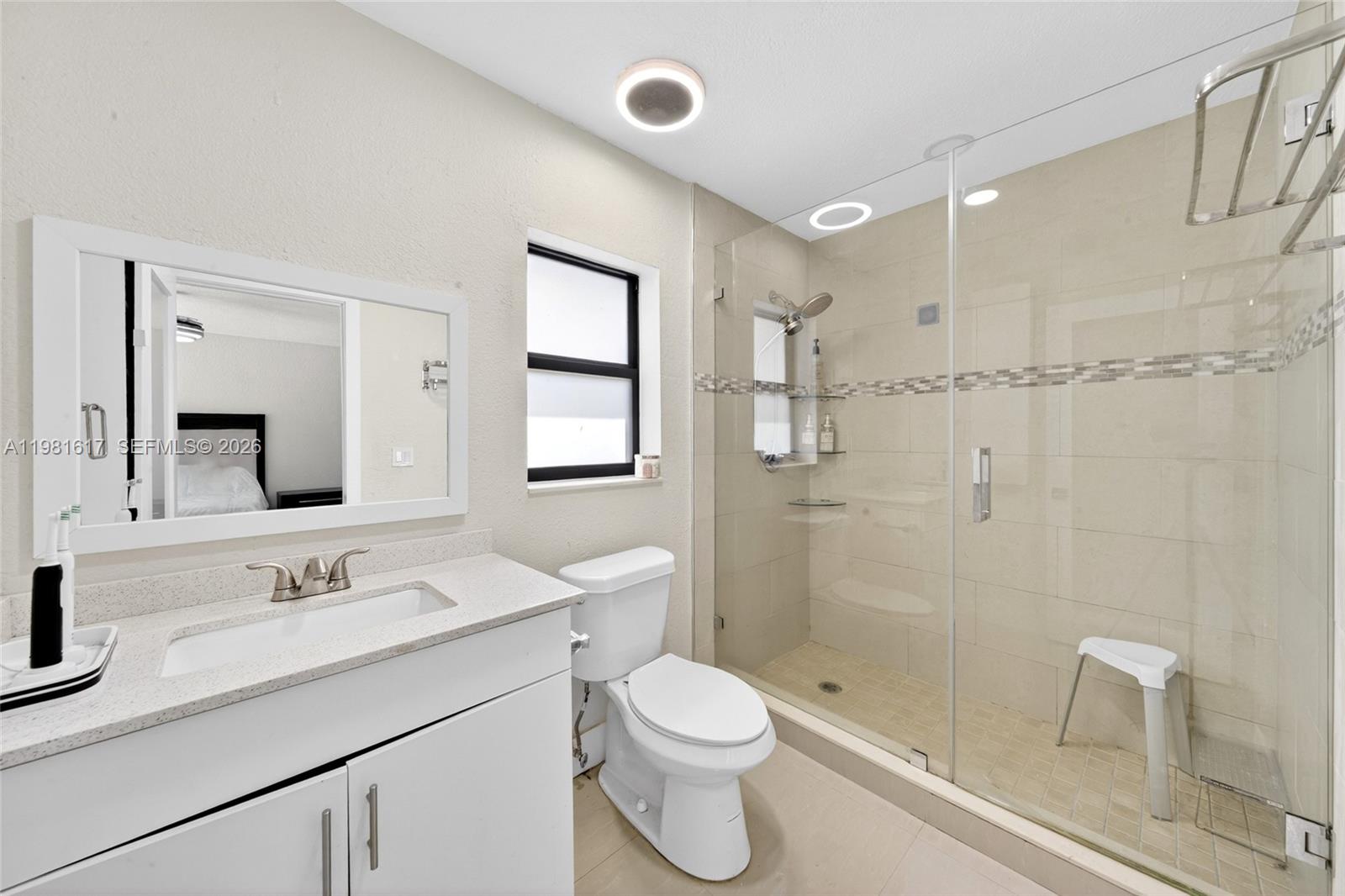 11951 Southwest 120th Terrace Miami, FL 33186 - Photo 26 of 55 a bathroom with a granite countertop sink a toilet a shower and a mirror
