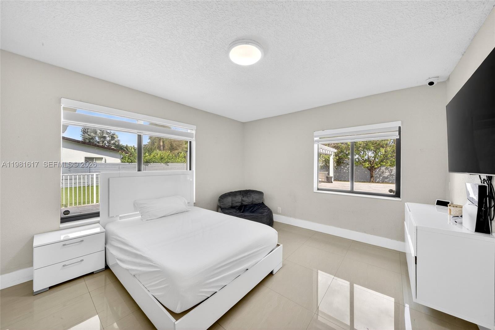 11951 Southwest 120th Terrace Miami, FL 33186 - Photo 30 of 55 a bedroom with a white bed and a large window