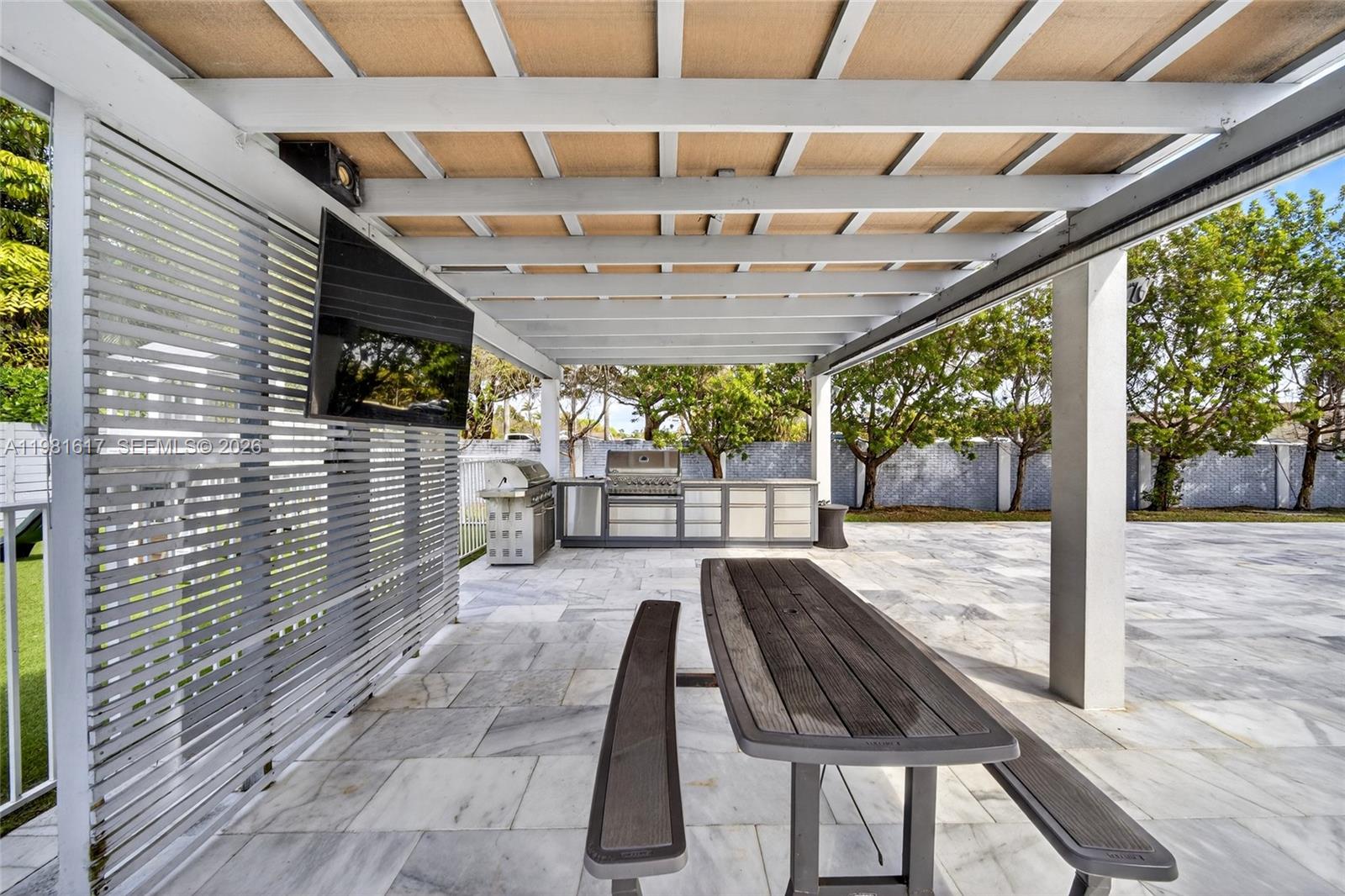 11951 Southwest 120th Terrace Miami, FL 33186 - Photo 43 of 55 a view of a patio with table and chairs a barbeque with wooden floor and roof with floor to ceiling window