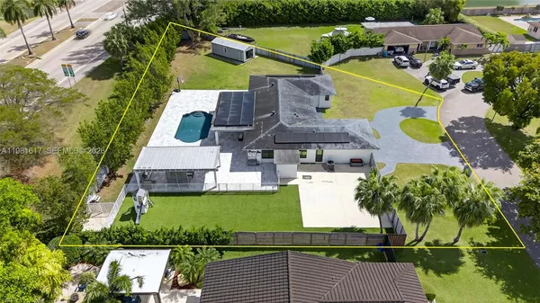 an aerial view of residential houses with outdoor space and swimming pool