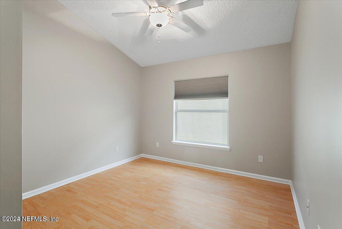 1212 Coghill Circle St. Augustine, FL 32092 - Photo 13 of 18 an empty room with a chandelier fan and windows