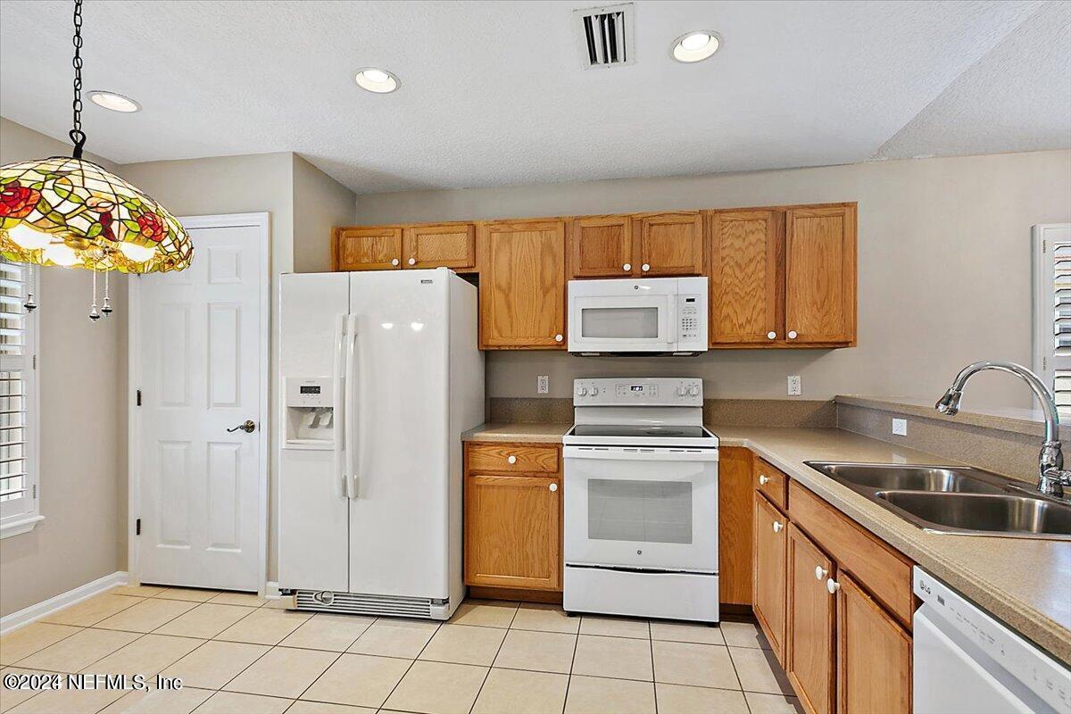 1212 Coghill Circle St. Augustine, FL 32092 - Photo 6 of 18 a kitchen with stainless steel appliances granite countertop a refrigerator sink and stove