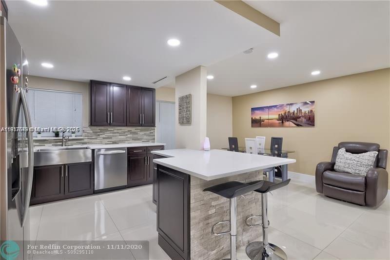 3100 Riverside Drive, Unit 107 Coral Springs, FL 33065 - Photo 11 of 33 a kitchen with stainless steel appliances kitchen island granite countertop a sink and a refrigerator