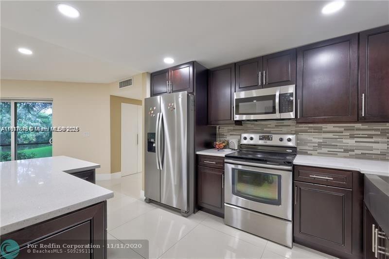 3100 Riverside Drive, Unit 107 Coral Springs, FL 33065 - Photo 12 of 33 a kitchen with a stove a sink and a microwave