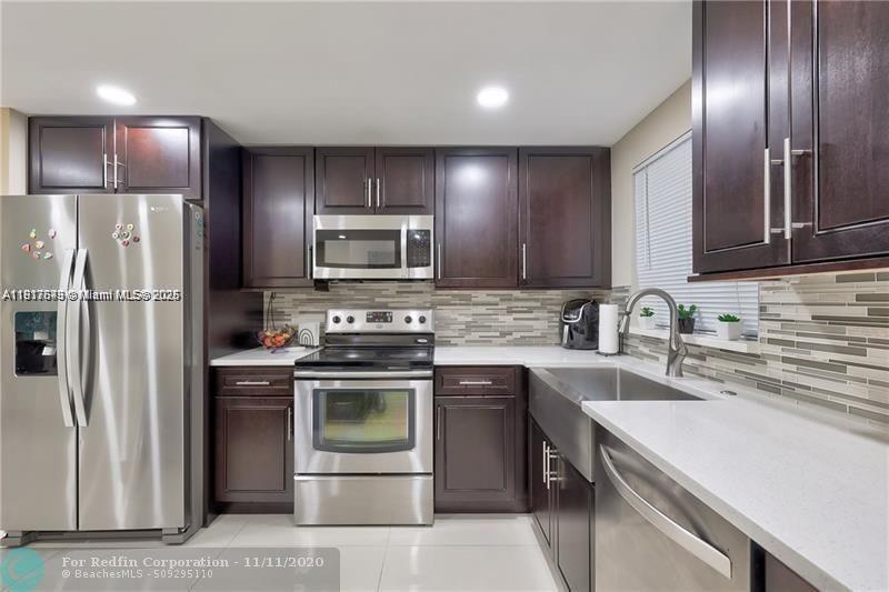 3100 Riverside Drive, Unit 107 Coral Springs, FL 33065 - Photo 13 of 33 a kitchen with a sink stainless steel appliances and cabinets
