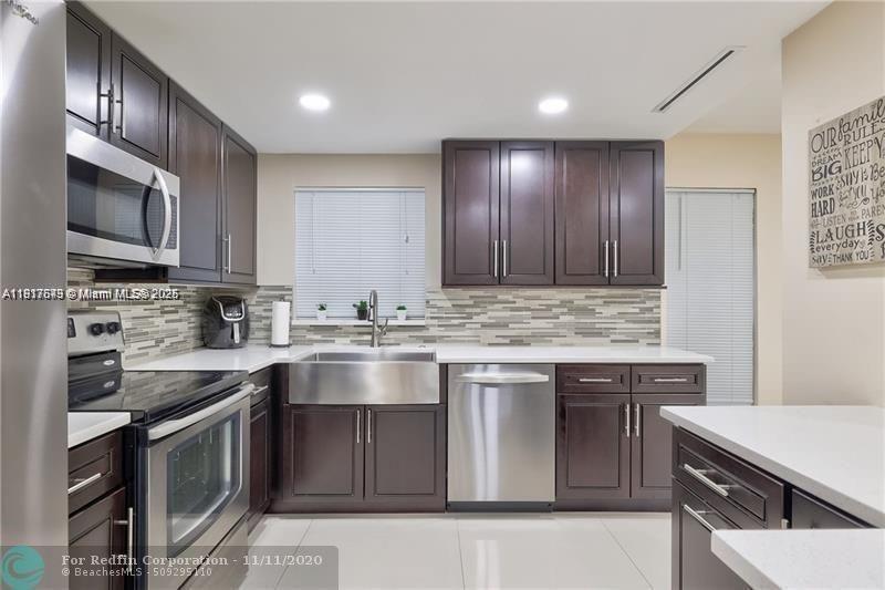 3100 Riverside Drive, Unit 107 Coral Springs, FL 33065 - Photo 15 of 33 a kitchen with stainless steel appliances granite countertop a sink stove and microwave