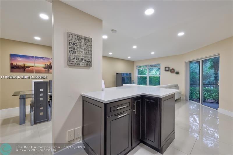 3100 Riverside Drive, Unit 107 Coral Springs, FL 33065 - Photo 16 of 33 a kitchen with kitchen island a sink table and chairs