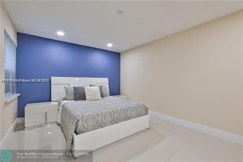 3100 Riverside Drive, Unit 107 Coral Springs, FL 33065 - Photo 17 of 33 a bedroom with a bed and a night stand
