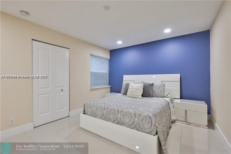 3100 Riverside Drive, Unit 107 Coral Springs, FL 33065 - Photo 19 of 33 a bedroom with a large bed and a potted plant