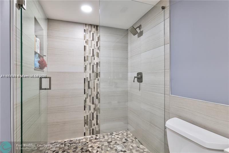 3100 Riverside Drive, Unit 107 Coral Springs, FL 33065 - Photo 22 of 33 a bathroom with a shower and a toilet