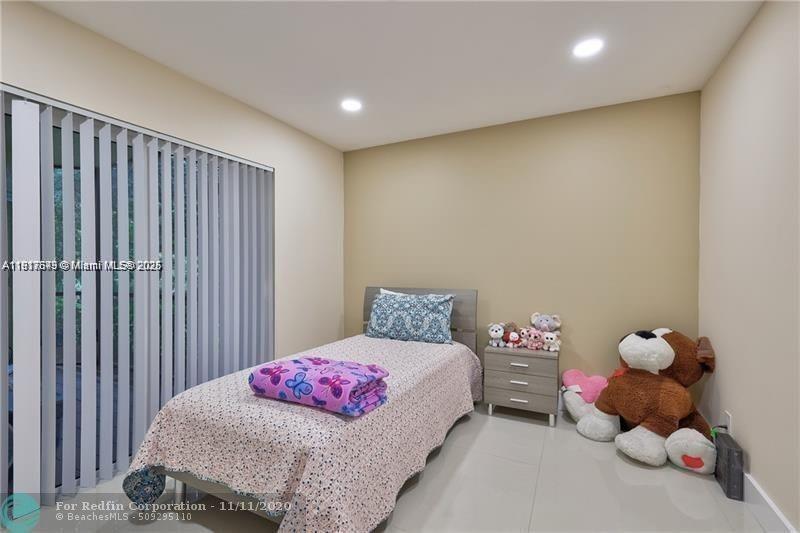 3100 Riverside Drive, Unit 107 Coral Springs, FL 33065 - Photo 24 of 33 a bedroom with a bed and a window