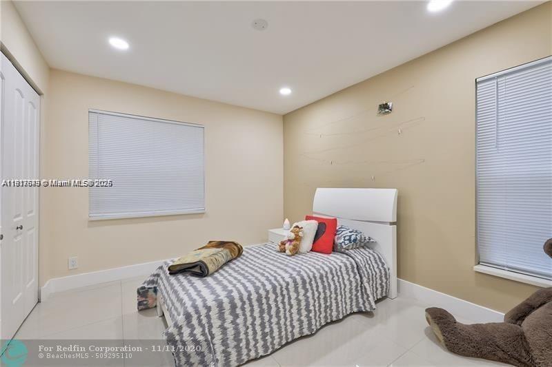 3100 Riverside Drive, Unit 107 Coral Springs, FL 33065 - Photo 28 of 33 a bedroom with a bed and couch